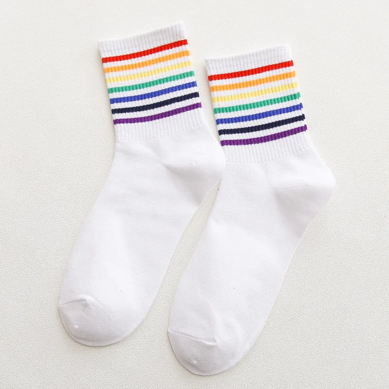 White socks with rainbow striped cuffs on a light gray background